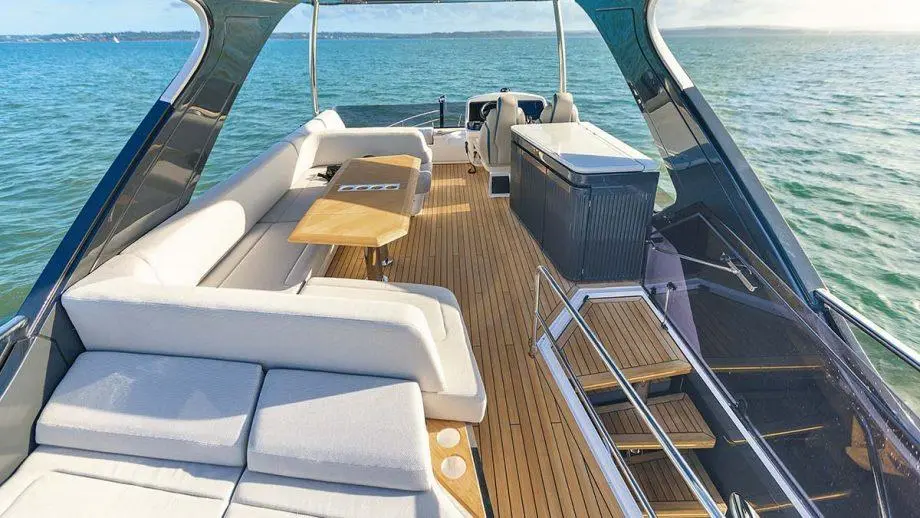 Modern yacht deck with a spacious lounge area, wooden flooring, and panoramic views of the water and horizon.
